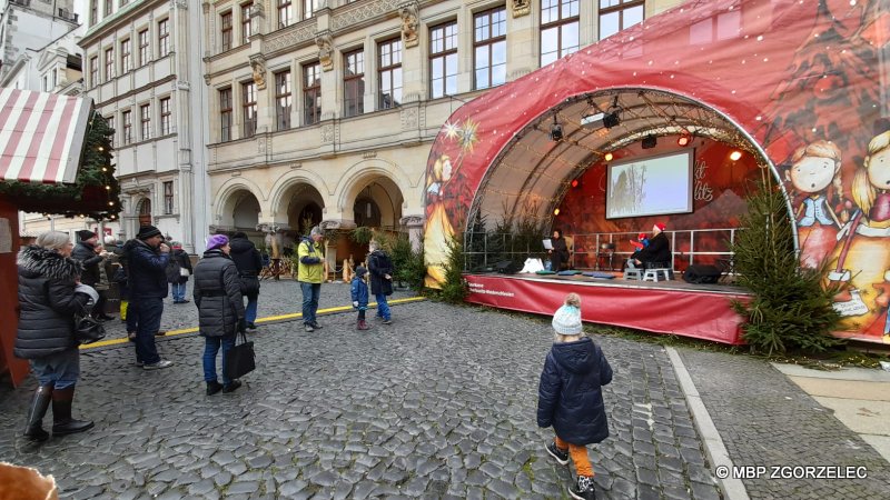 Bibliotekarka czyta świąteczne opowiadanie dla dzieci na Jarmarku Bożonarodzeniowym w Görlitz.