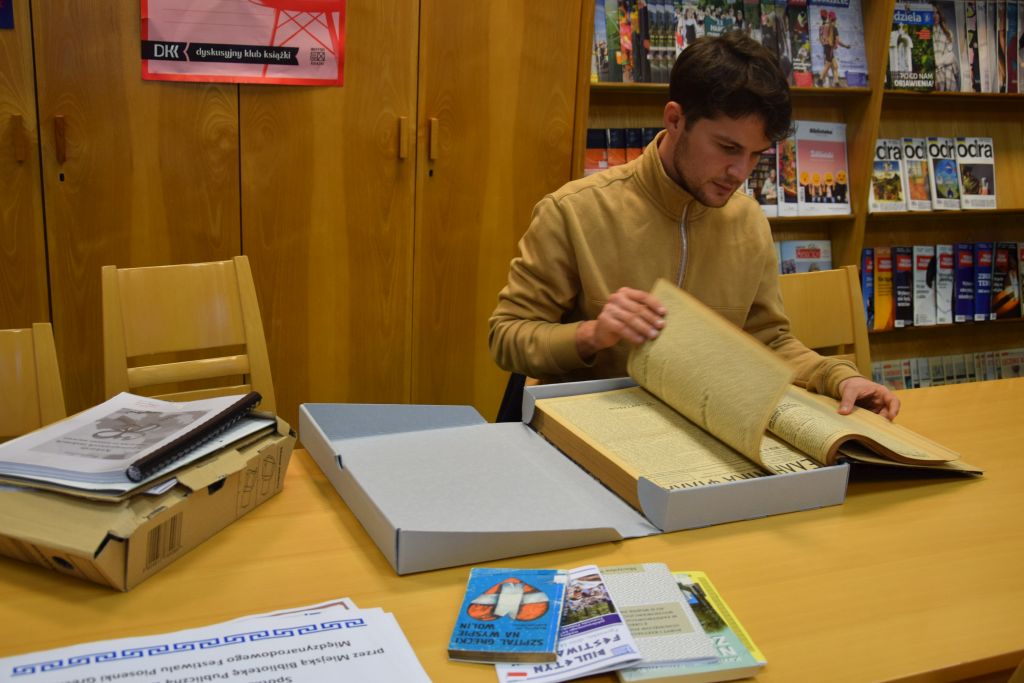 Student z Grecji przegląda w Czytelni MBP materiały dotyczące historii Greków.