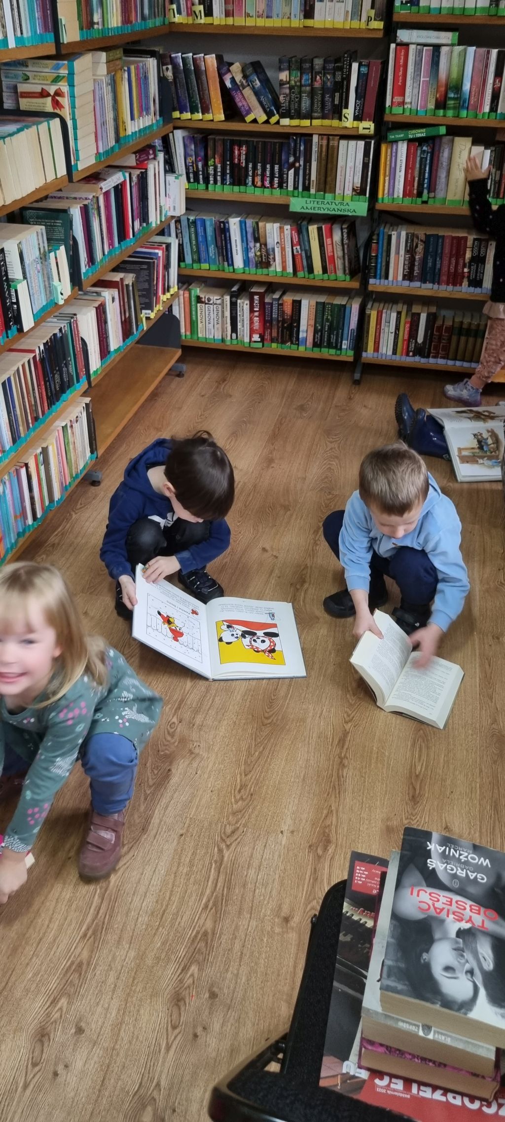 Dzieci przeglądają książki w bibliotece.