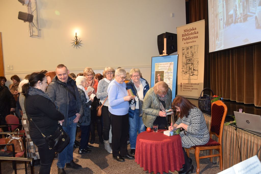Spotkanie autorskie z Katarzyną Janus. Autorka podpisuje książki.