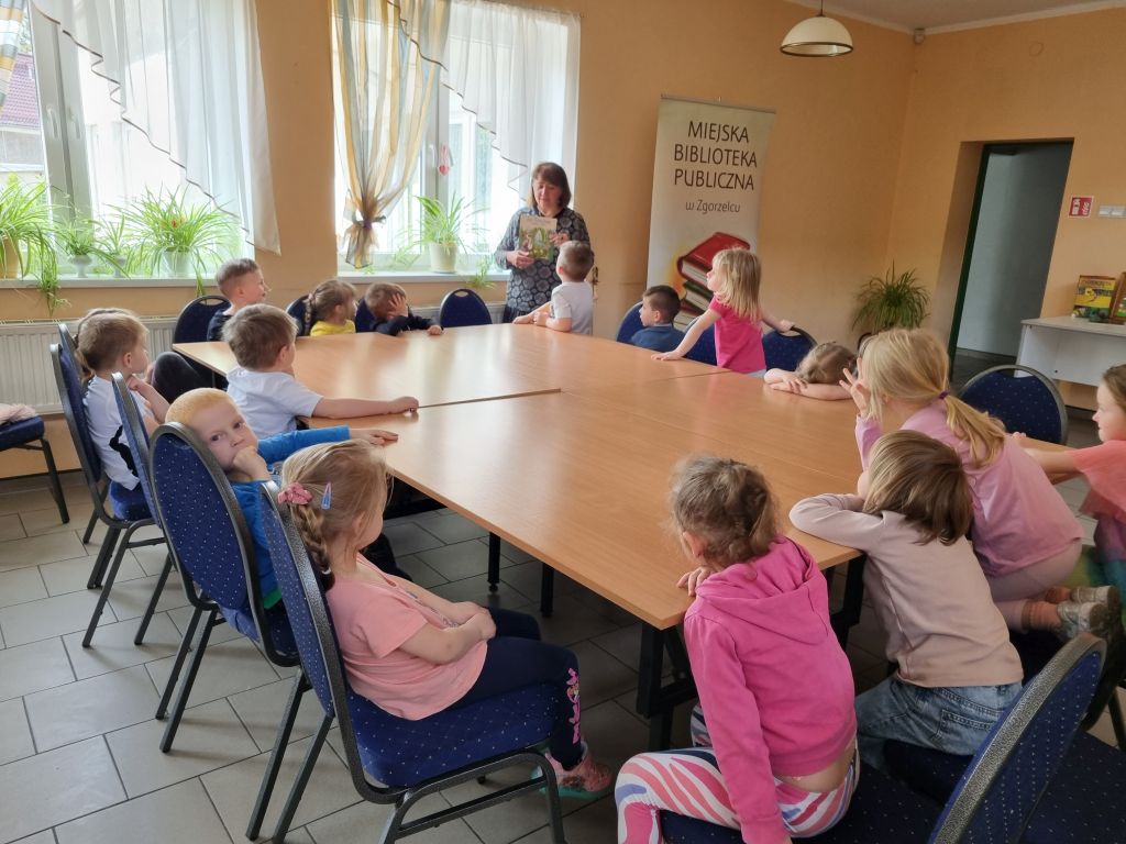 Bibliotekarka prezentuje przedszkolakom książkę z wierszem Jana Brzechwy pt. "Żuraw i czapla".