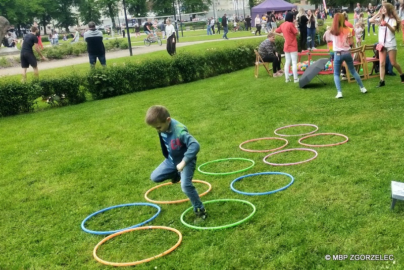 Na skwerze ks. Jerzego Popiełuszki jest chłopiec, który przeskakuje przez obręcze hula hop.