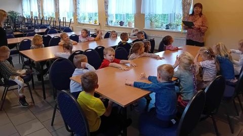 Bibliotekarka czyta bajkę dla przedszkolaków o jesieni.