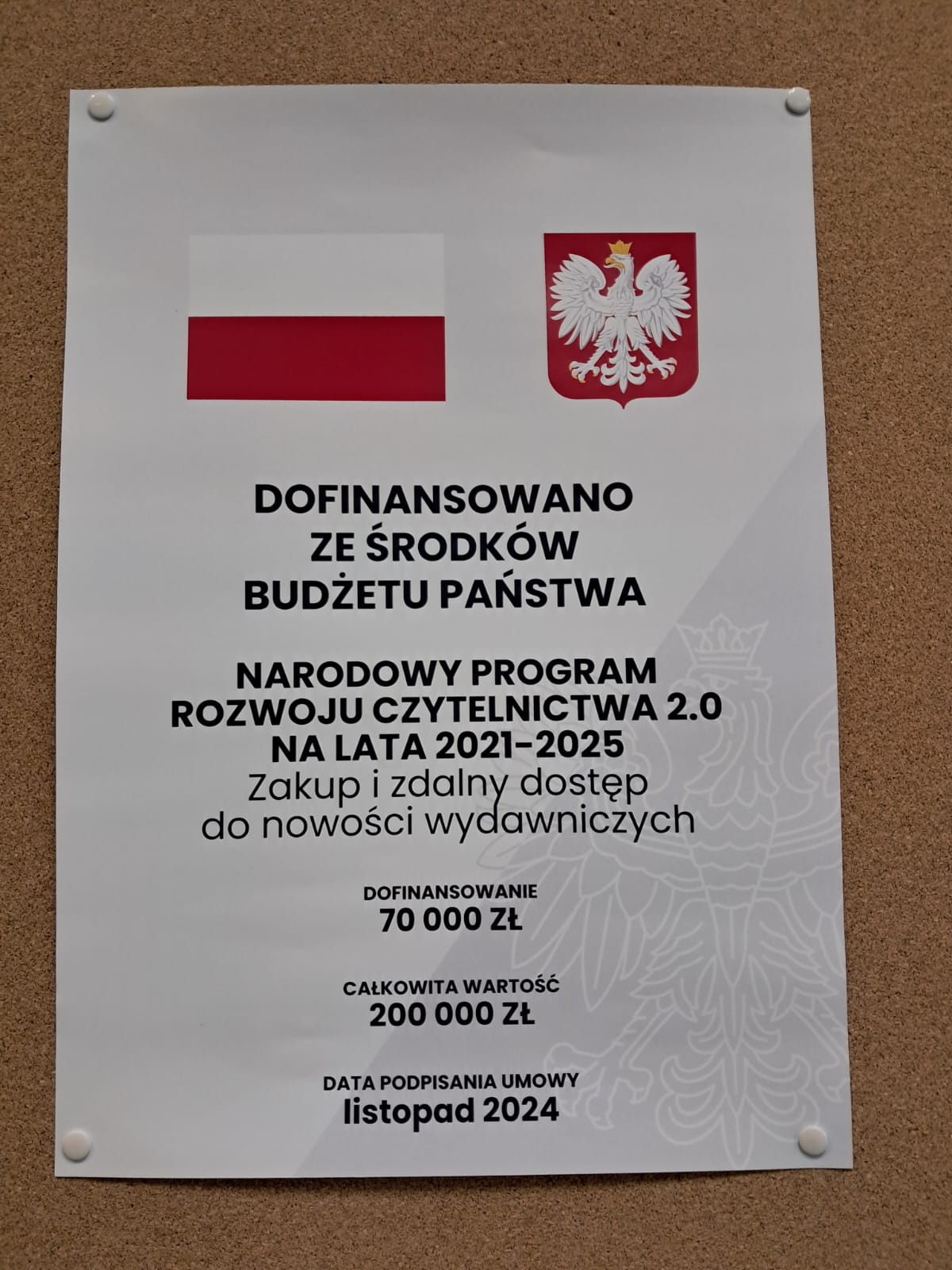 Plakat z napisem: DOFINANSOWANO ZE ŚRODKÓW BUDŻETU PAŃSTWA NARODOWY PROGRAM ROZWOJU CZYTELNICTWA 2.0 NA LATA 2021-2025 Zakup i zdalny dostęp do nowości wydawniczych DOFINANSOWANIE 70 000 ZŁ CAŁKOWITA WARTOŚĆ 200 000 ZŁ DATA PODPISANIA UMOWY listopad 2024