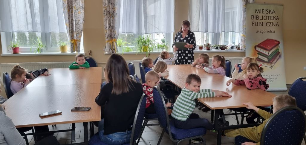 Bibliotekarka czyta dla dzieci wiersz pt. "Pory roku".