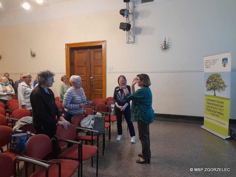 W sali widowiskowej Miejskiego Domu Kultury w Zgorzelcu prezes Stowarzyszenia TUTW - Pani Anna Śliwińska zachęca słuchaczy do wspólnego śpiewu.