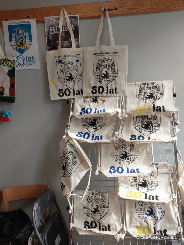 W pomieszczeniu biblioteki, wiszą torby i workoplecaki z herbem Miasta Zgorzelec, malowane przez dzieci podczas zajęć.