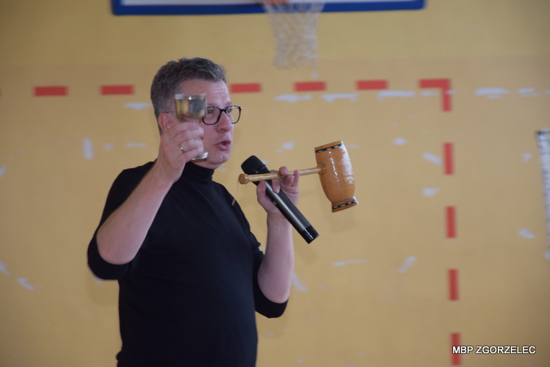 W sali gimnastycznej Szkoły Podstawowej nr 5 im. Marii Skłodowskiej-Curie, Pan Marek pokazuje puchary, z których piją sok z cytryny Damy i Kawalerowie odznaczeni przez dzieci Orderem Uśmiechu. 