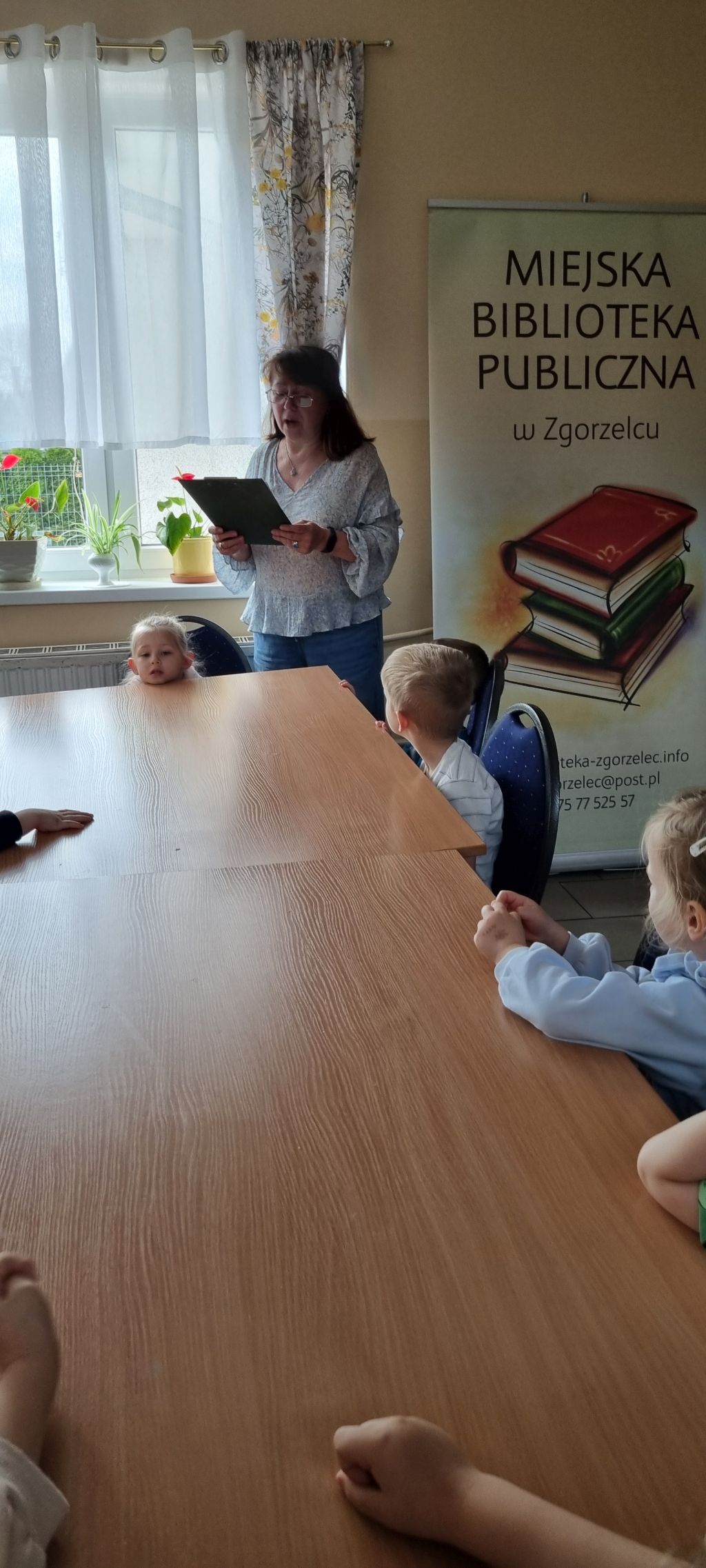 Bibliotekarka czyta dzieciom bajkę.