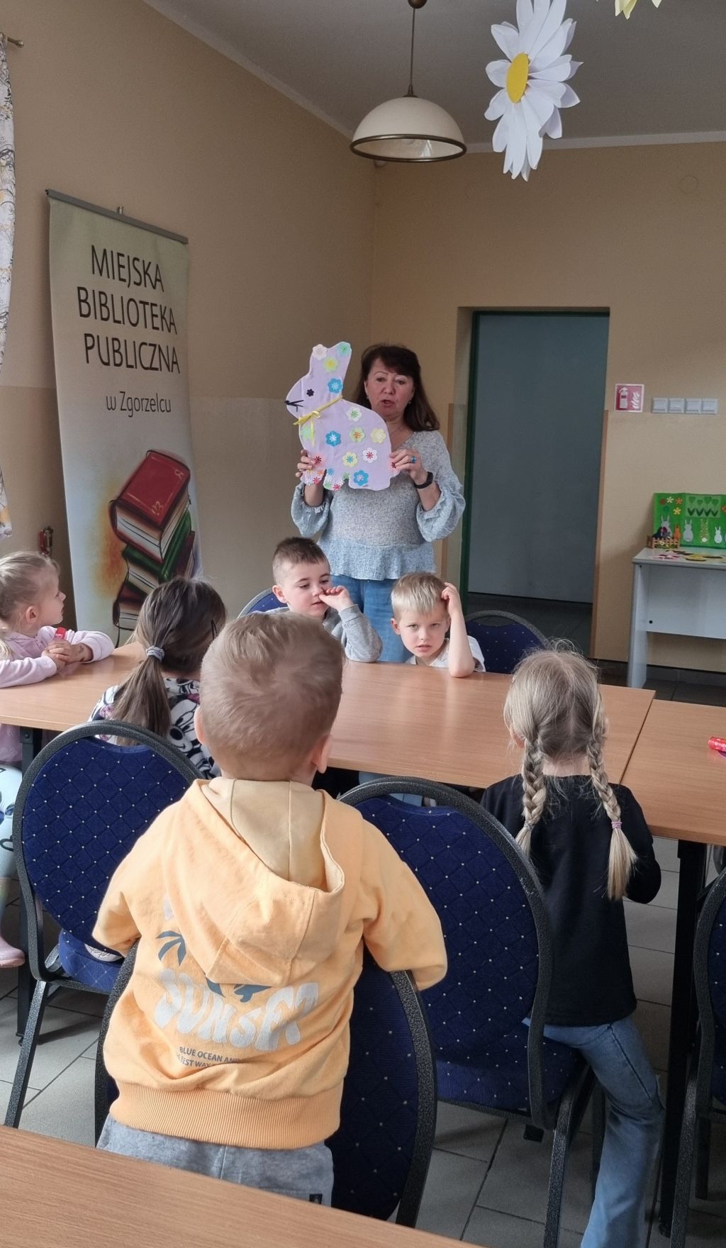 Bibliotekarka pokazuje dzieciom zająca.