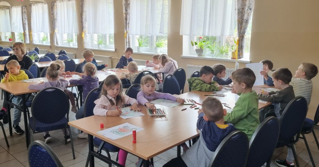 Dzieci wykonują prace plastyczne podczas spotkania w bibliotece. Zdjęcie jest odnośnikiem do wpisu "Bukiecik dla mamy".