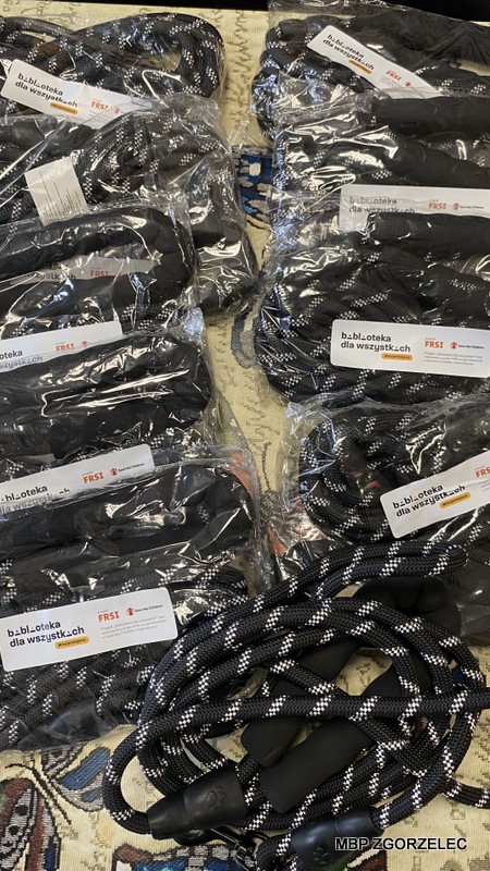 Zbliżenie na zapakowane liny dla psów z etykietami „Biblioteka dla wszystkich istot”, przygotowane do rozdania dla schroniska w ramach akcji.