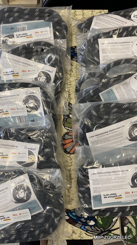 Zbliżenie na zapakowane liny treningowe dla psów z etykietami „Biblioteka dla wszystkich istot”, przygotowane do rozdania dla schroniska w ramach akcji.