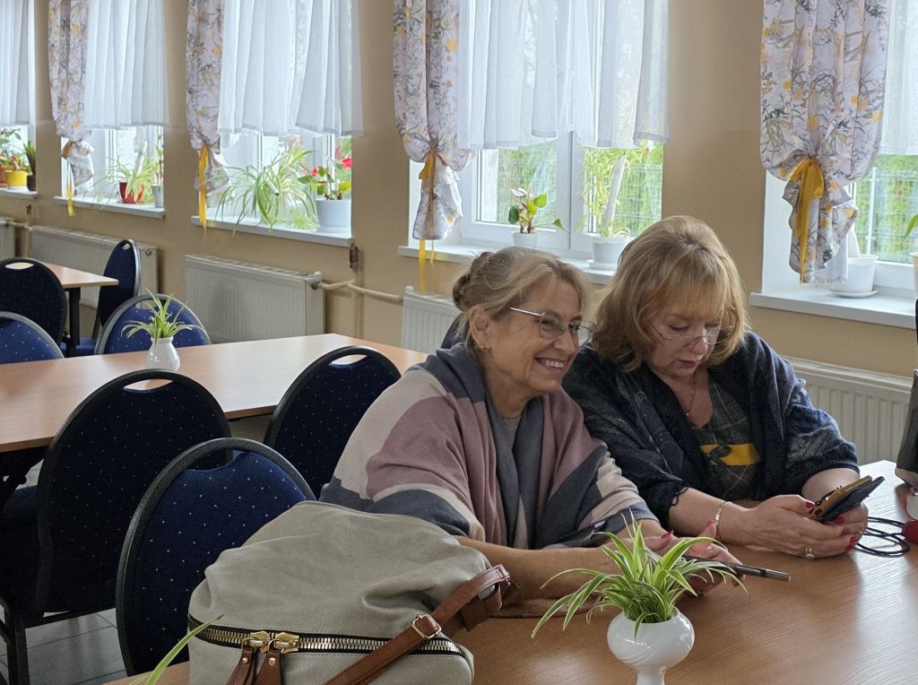Spotkanie klubowiczek DKK, czytelniczka wystukuje w&nbsp;komórce na Legimi tytuł omawianej książki "Gwiazdka pełna marzeń".