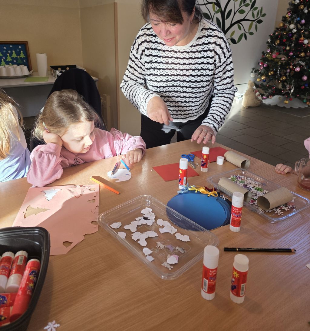 Przedszkolaki wspólnie z&nbsp;Seniorkami tworzą ozdoby świąteczne.