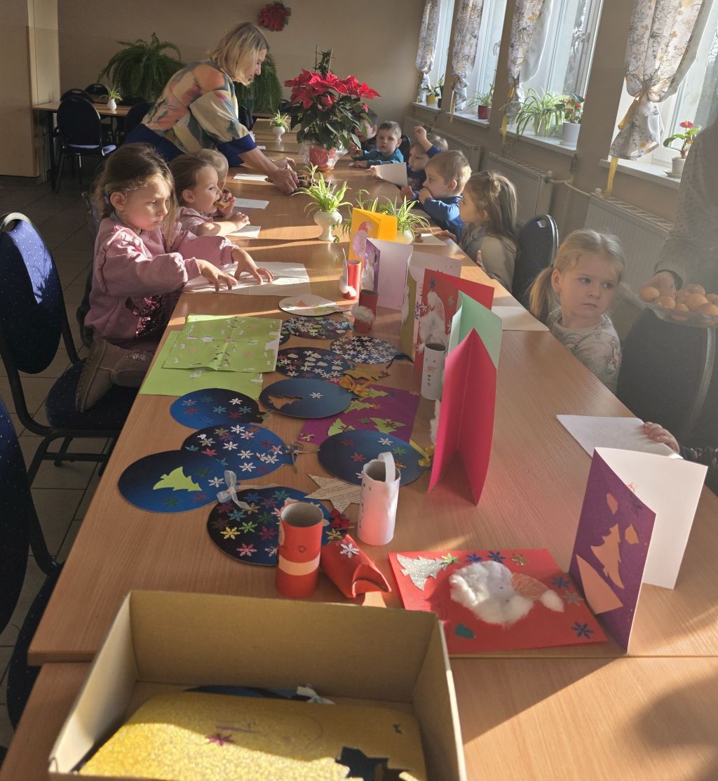Przedszkolaki wspólnie z&nbsp;Seniorkami tworzą ozdoby świąteczne.