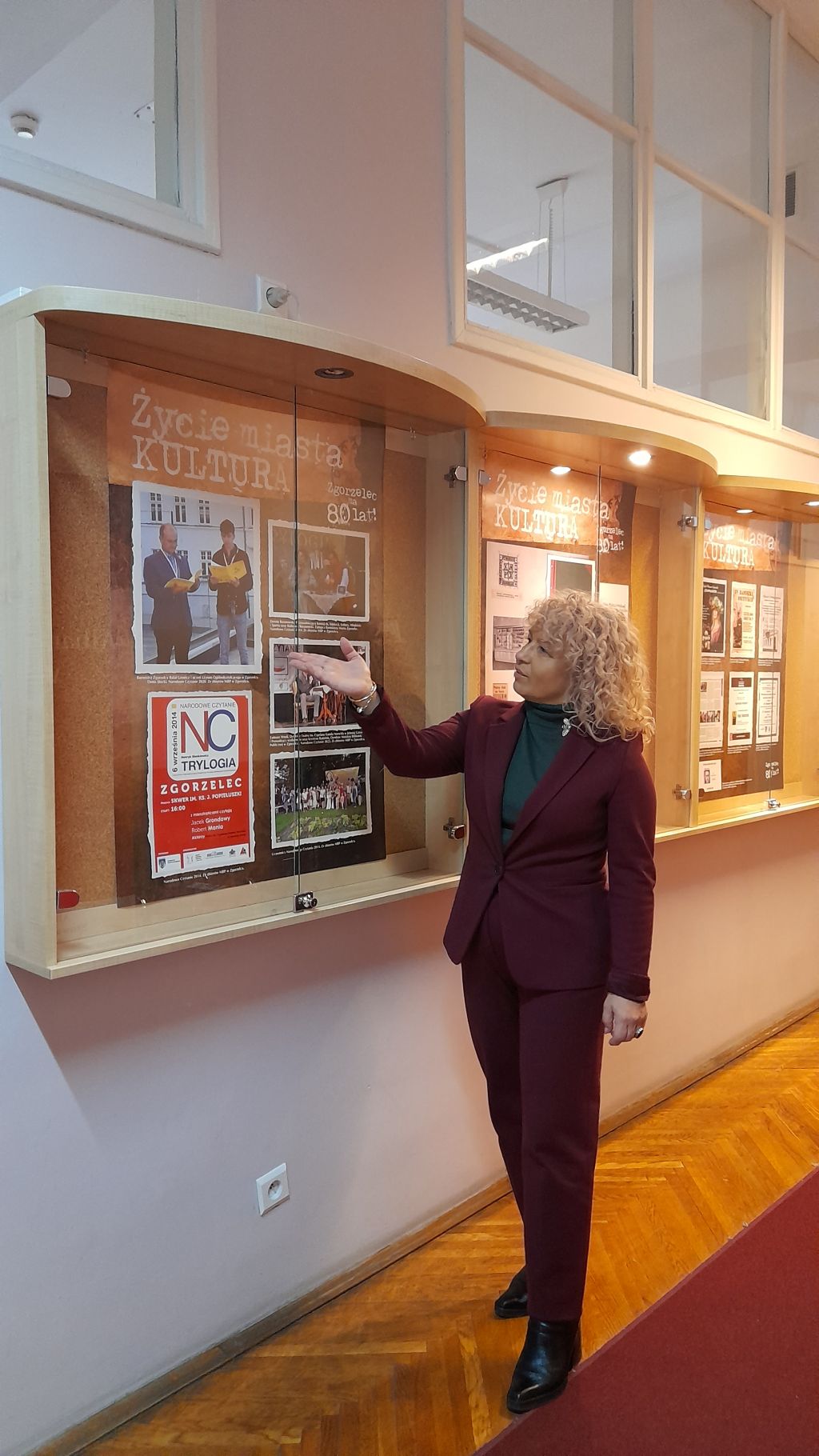 Dyrektor MBP Krystyna Radzięta wskazuje na jedną z&nbsp;plansz wystawy “Zgorzelec ma 80 lat!” prezentowanej w&nbsp;Dolnośląskiej Bibliotece Publicznej we Wrocławiu.