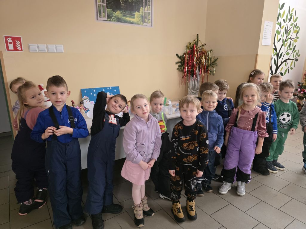 Grupa przedszkolaków pozuje do zdjęcia podczas spotkania w&nbsp;bibliotece.